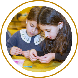 two girls making a bracelet