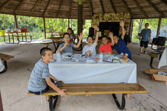 boys smiling and sitting at a picnic table